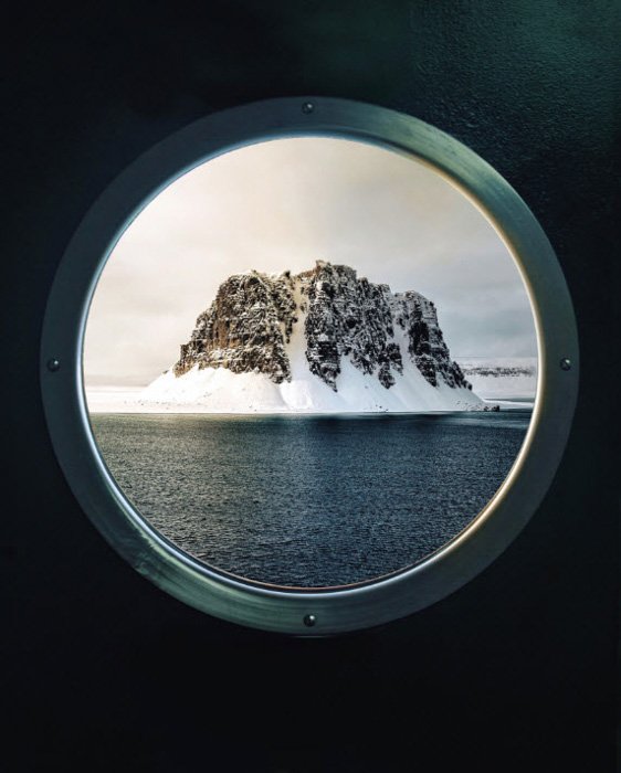 Айсберг виден через иллюминатор корабля, фото Simone Bramante