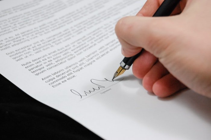 Close up of the person signing a real estate photography contract