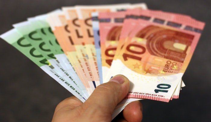 Рука, держащая веер банкнот евро