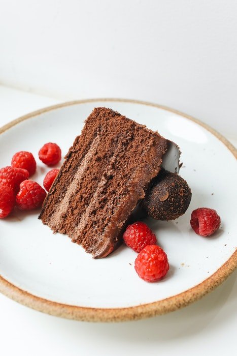 Высокоугловое фото вкусного шоколадного торта на тарелке с ягодами