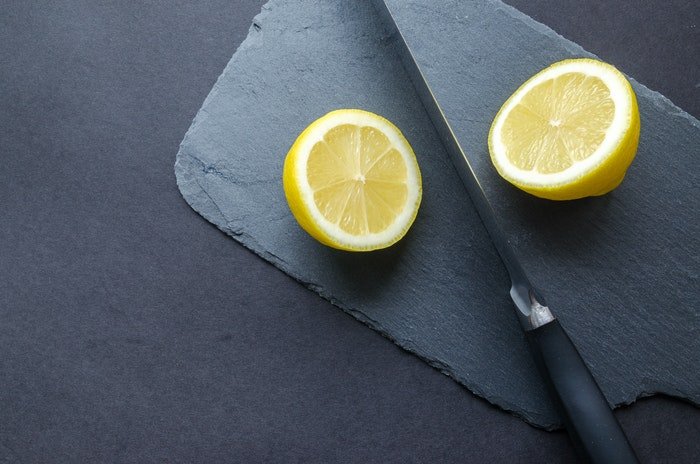 Diy food photography background with a knife and a sliced lemon
