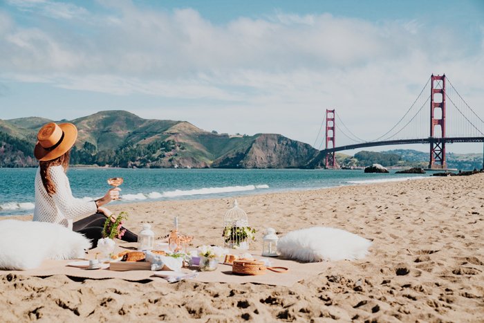 Девушка позирует для пышной фотосессии пикника на пляже