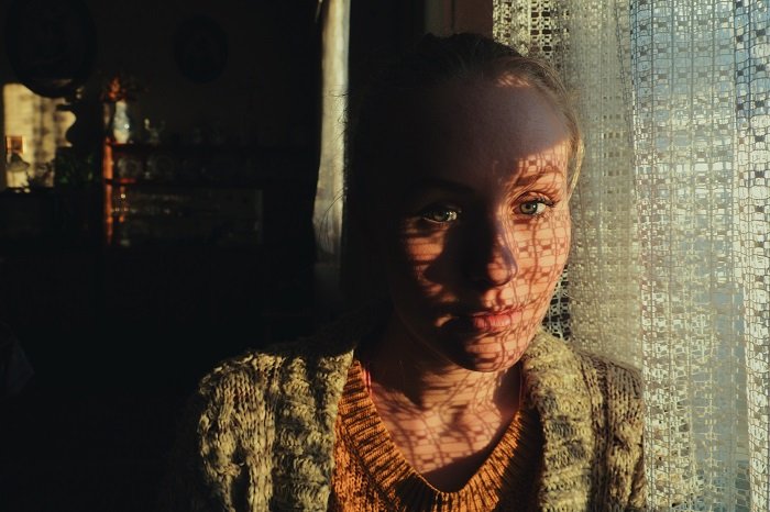 Портрет женщины у окна, снятый с использованием точечного замера