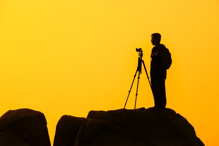 Фотограф дикой природы в силуэте на фоне заката
