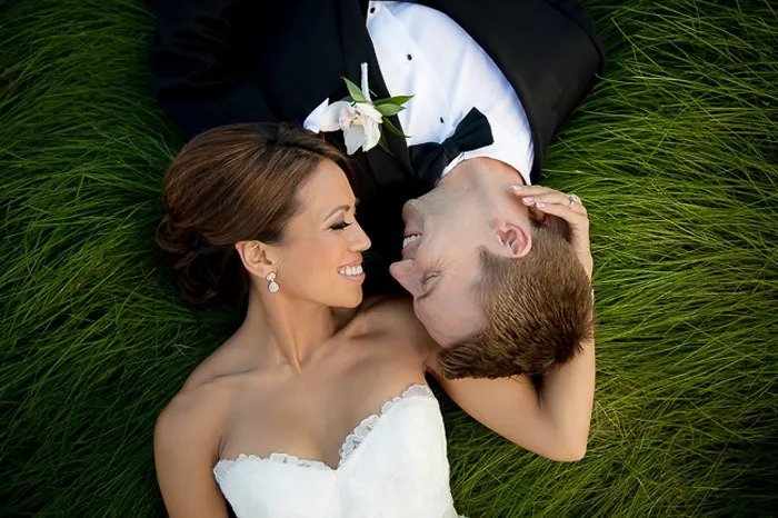 Свадебный портрет молодоженов, лежащий на траве