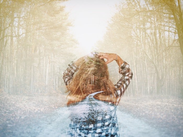 Изображение девушки, идущей через лес, с двойной экспозицией