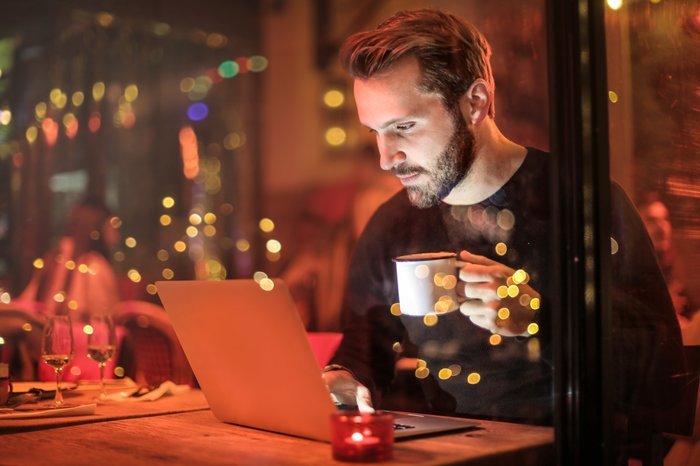 Мужчина использует свой ноутбук в кафе