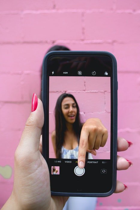 Прикольное фото девушки на экране iphone, которая сама щелкает затвором