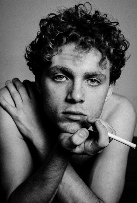 Черно-белый портрет молодого человека, курящего сигарету