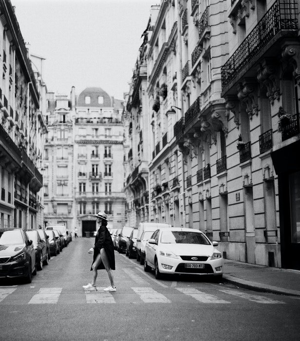 Черно-белая фотография девушки, переходящей улицу