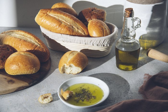 A beautiful food still life of rustic baskets of bread and olive oil