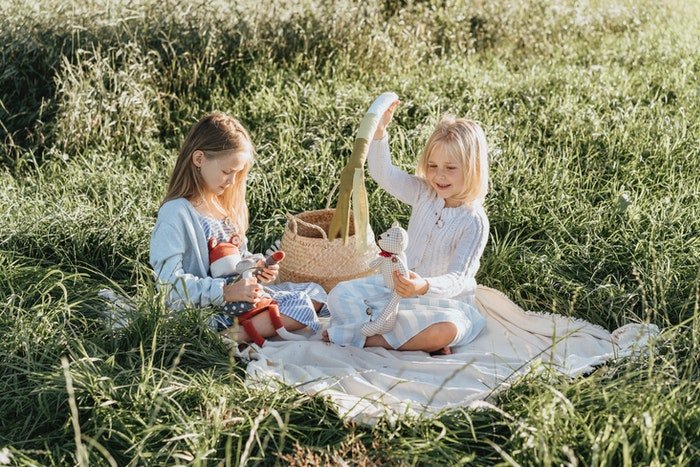 Портрет двух маленьких девочек, играющих с игрушками