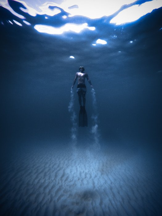 Фотография дайвера под водой с виньеткой по краям
