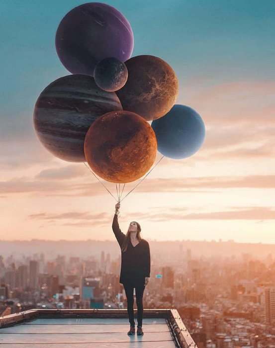 Художественная фотография девушки, держащей планеты как воздушные шары