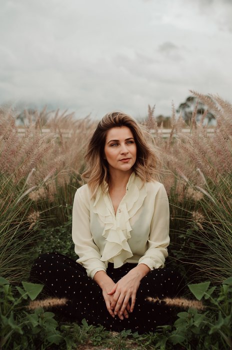 пасмурный день портретная фотография женщины, сидящей в пшеничном поле