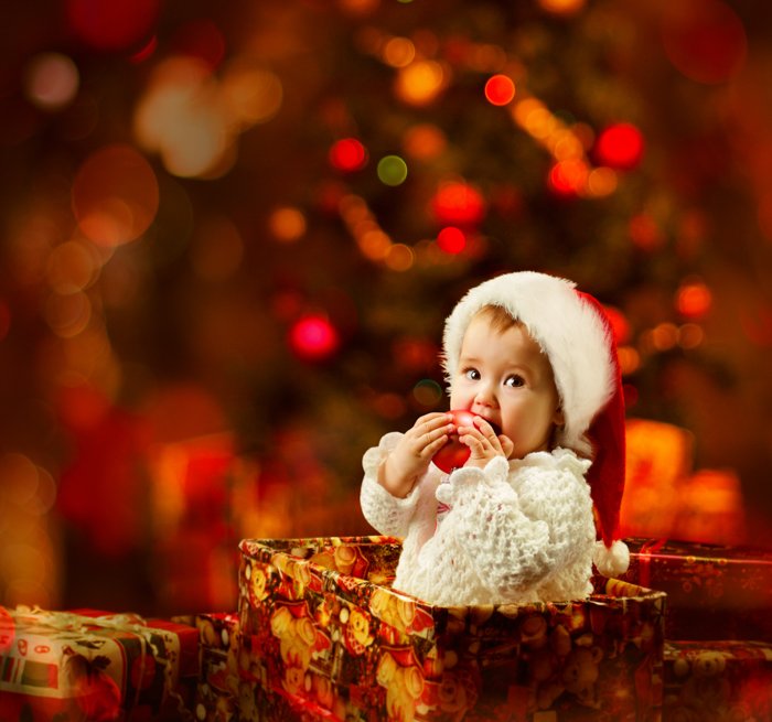 Сладкая рождественская фотография младенца в подарочной коробке перед рождественской елкой