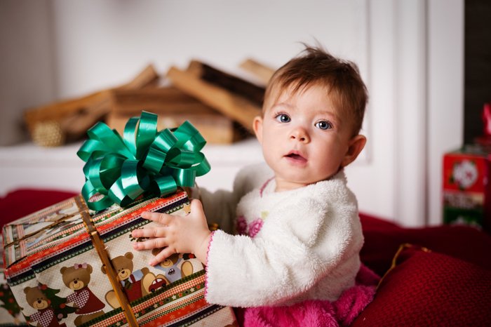 Милая детская рождественская фотография маленькой девочки с подарком