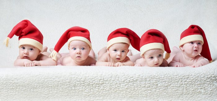 Милая детская рождественская фотосессия пяти малышей в шапках Санты
