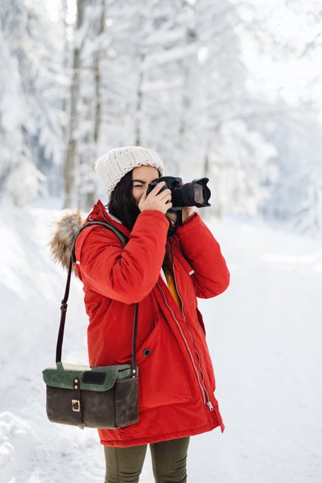 Фотограф снимает зимние фотографии на улице