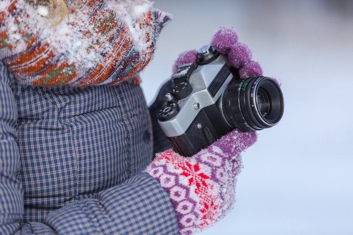 Крупный план фотографа, снимающего снег