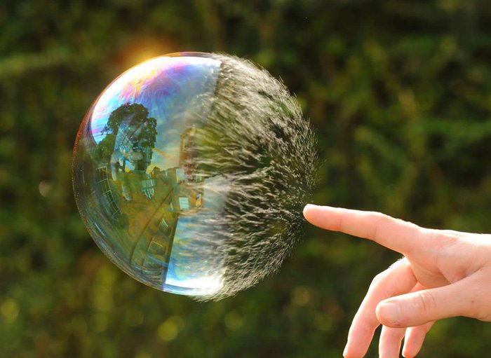 Человек трогает огромный пузырь