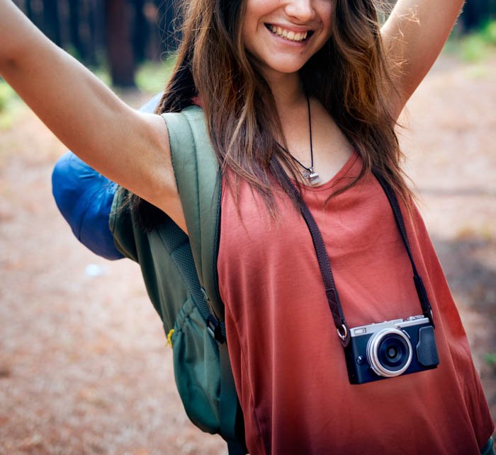 Молодой фотограф-путешественник позирует со своей камерой