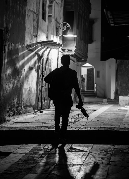 черно-белый силуэт фотографа возле уличного фонаря