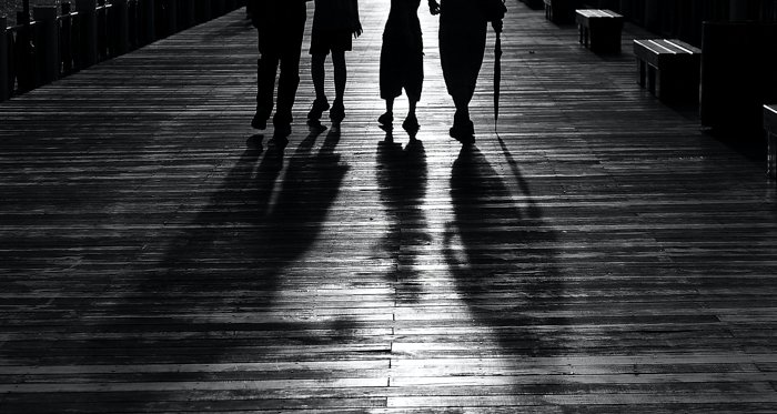 черно-белое изображение четырех человек по пояс и с тенями