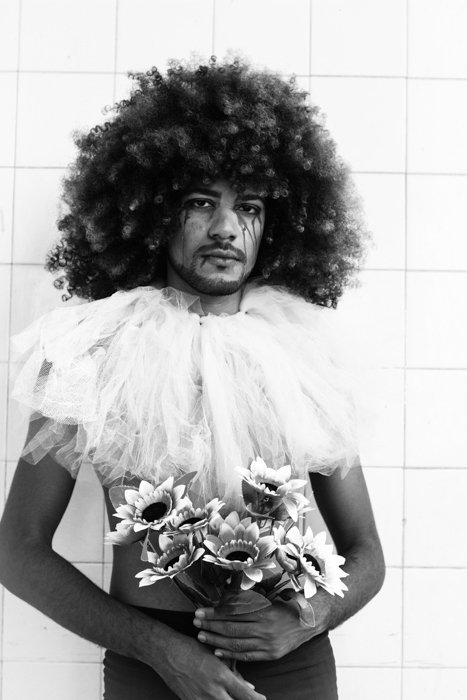 стилистическое изображение человека с афро, держащего искусственные цветы