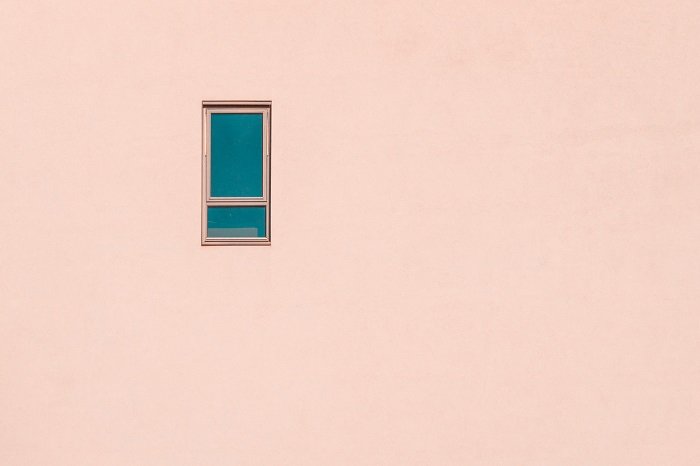 минималистская фотография маленького окна на фасаде розового здания