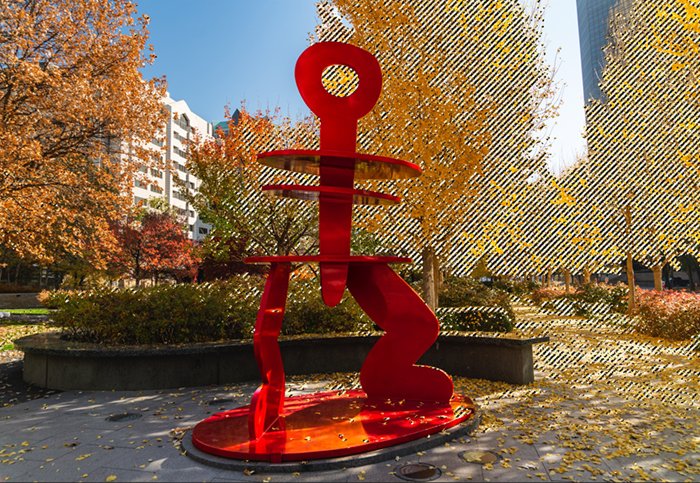 изображение красной скульптуры с желтыми листьями, выбранное в фотошопе