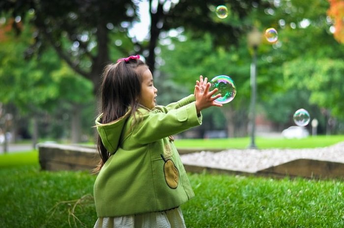 ребенок играет с пузырями