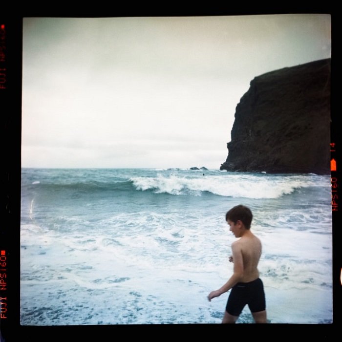 фотография мальчика на пляже, снятая на просроченную пленку