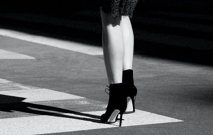 Черно-белая абстрактная фотография женских ног и ступней на высоких каблуках на тротуаре