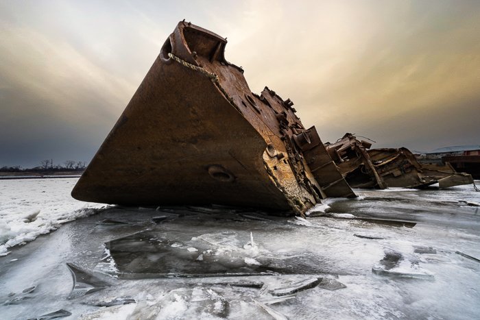 Rusted shipwreck on ice water with AI sky replaced using Adobe Photoshop