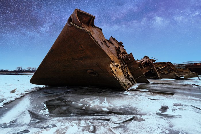 Rusted shipwreck on ice water with the starry sky added using Picnic