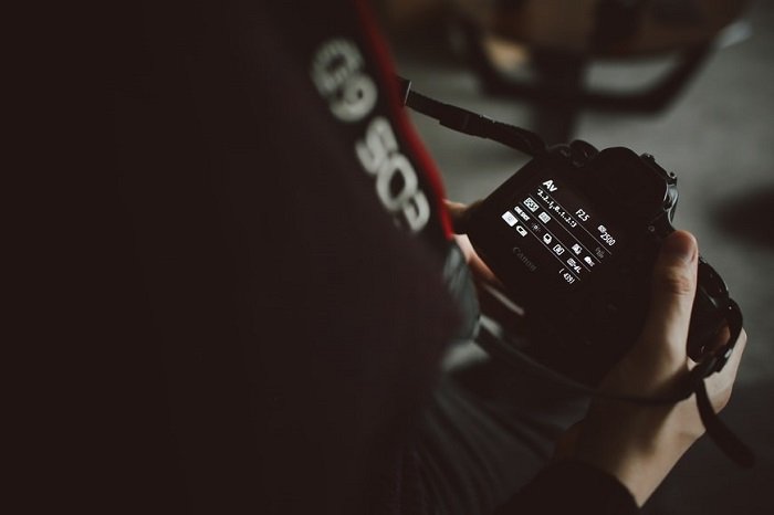 фотограф регулирует настройки своей камеры для съемки в черном свете