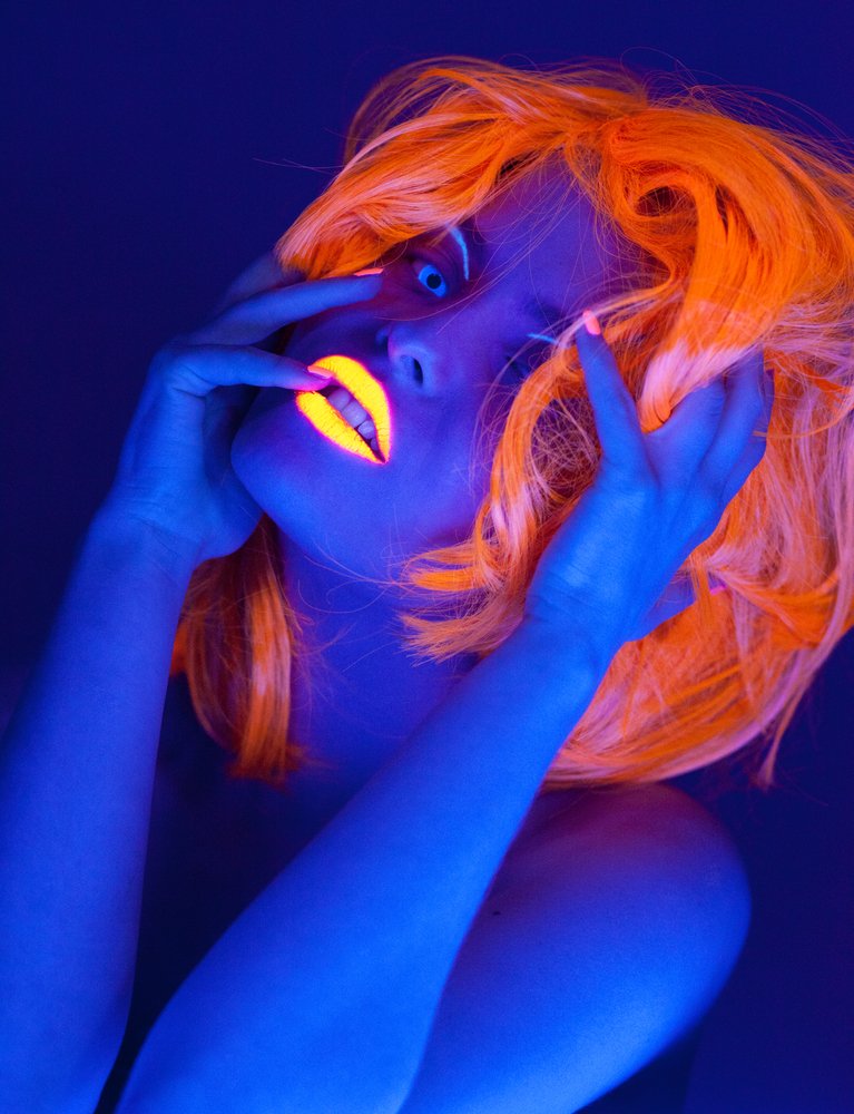 советы по фотографии в черном свете: портрет женщины с ультрафиолетовой помадой и париком, снятый в ультрафиолетовом свете