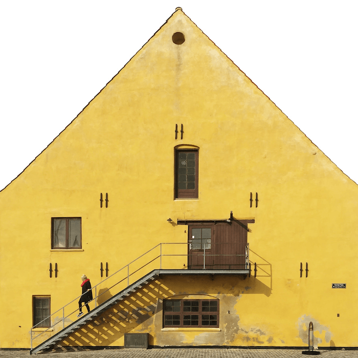 Городская фотография: Человек идет по лестнице перед большим желтым зданием