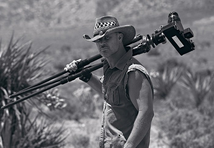 Фотография Петра Лика, держащего штатив в пустыне