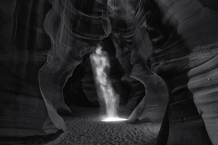 Черно-белая фотография облака пыли в пещере